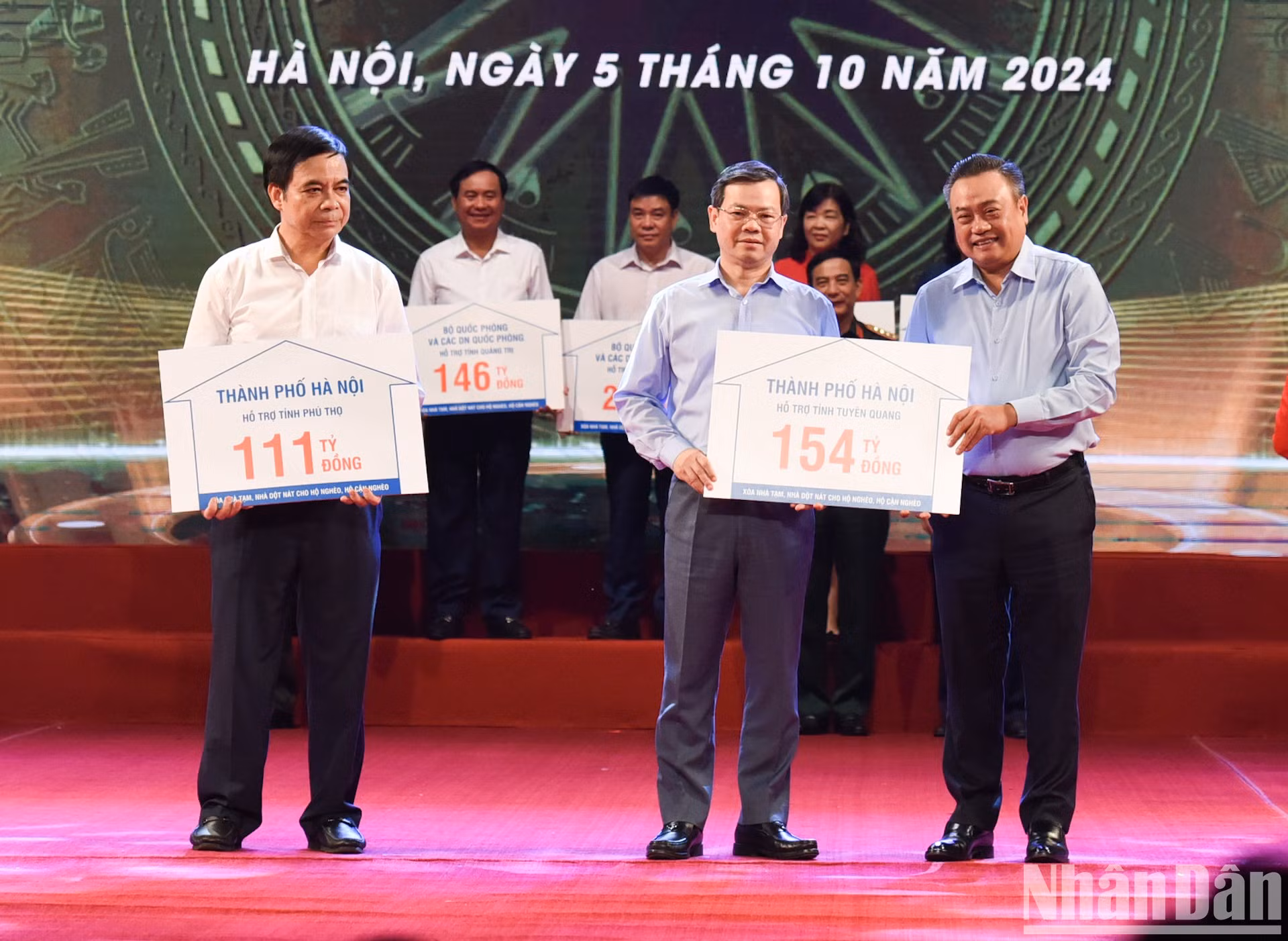 El presidente del Comité Popular de Hanói, Tran Sy Thanh, entrega una asistencia financiera a algunas localidades.