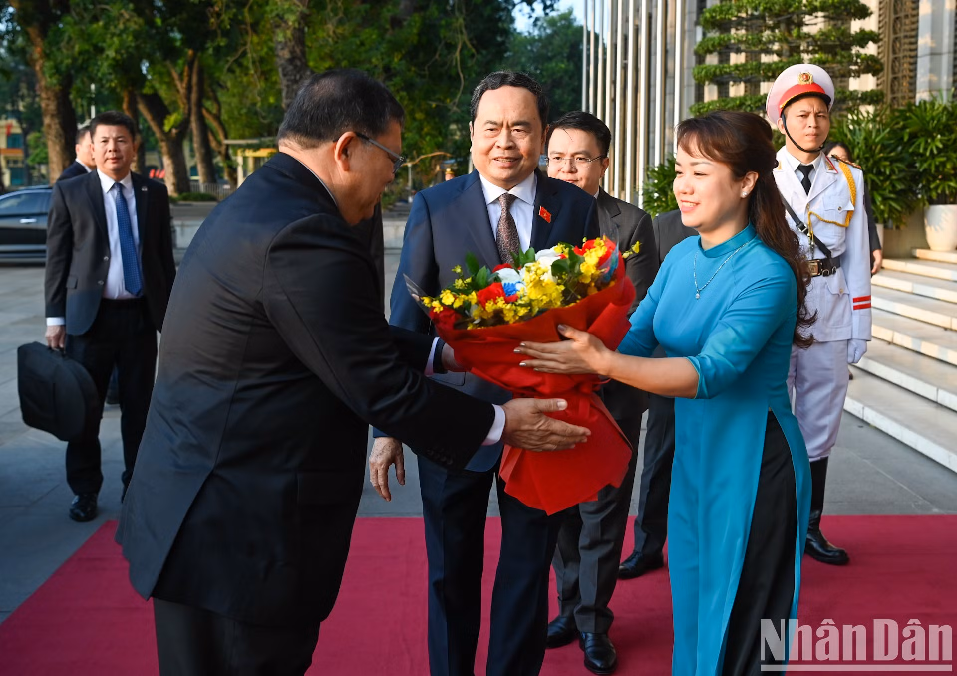 Una personal de la Oficina de la Asamblea Nacional regala flores de bienvenida al máximo legislador de Malasia.