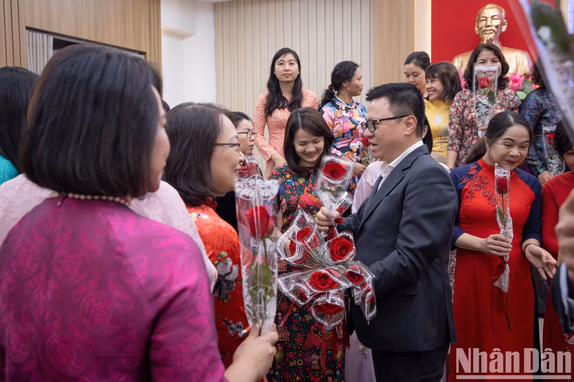 El presidente-editor Le Quoc Minh regala flores a las reporteras y trabajadoras.