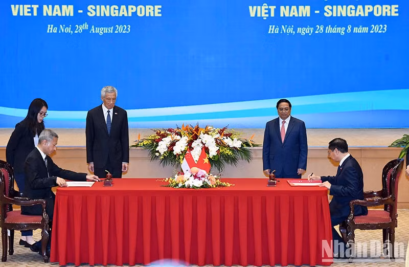Pham Minh Chinh y Lee Hsien Loong presencian la firma del acuerdo entre los Ministerios de Relaciones Exteriores de dos países sobre el Programa de Investigación Temática para Altos Funcionarios del Partido Comunista de Vietnam (2024 a 2026).