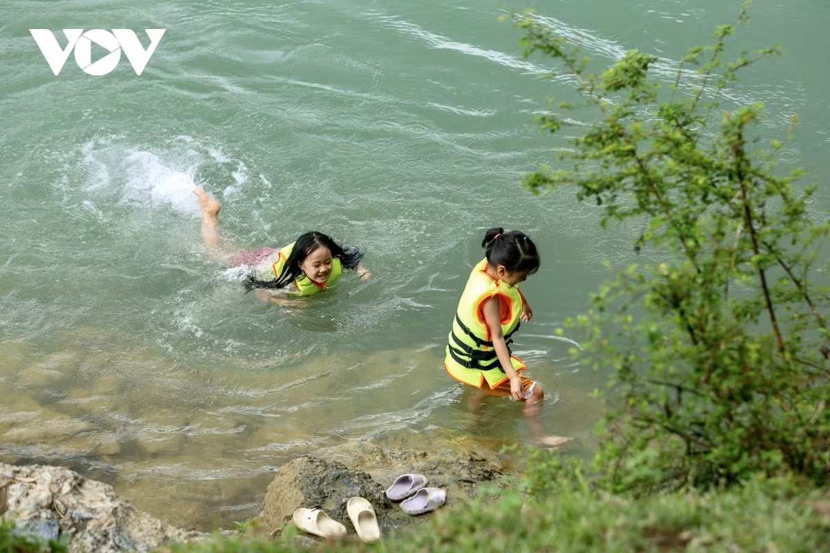 Niños nadan en el río.