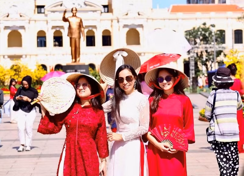 Vietnamitas que regresan del exterior exploran la calle de flores de Nguyen Hue. (Foto: qdnd.vn)