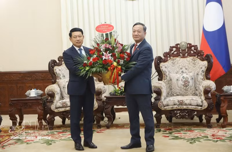 El embajador de Vietnam en Laos, Nguyen Minh Tam, transmite el arreglo floral de felicitación del primer ministro vietnamita Le Minh Hung al premier laosiano Saleumxay Kommasith. (Foto: VNA)