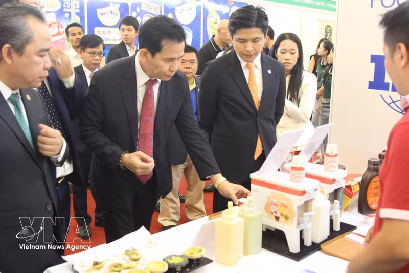 Delegados al evento visitan un stand de empresas vietnamitas de procesamiento de alimentos. (Foto: VNA)