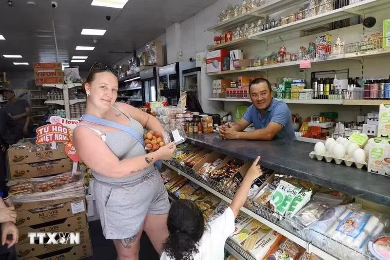 Una consumidora británica busca lichis vietnamitas en una tienda. (Fotografía: VNA)