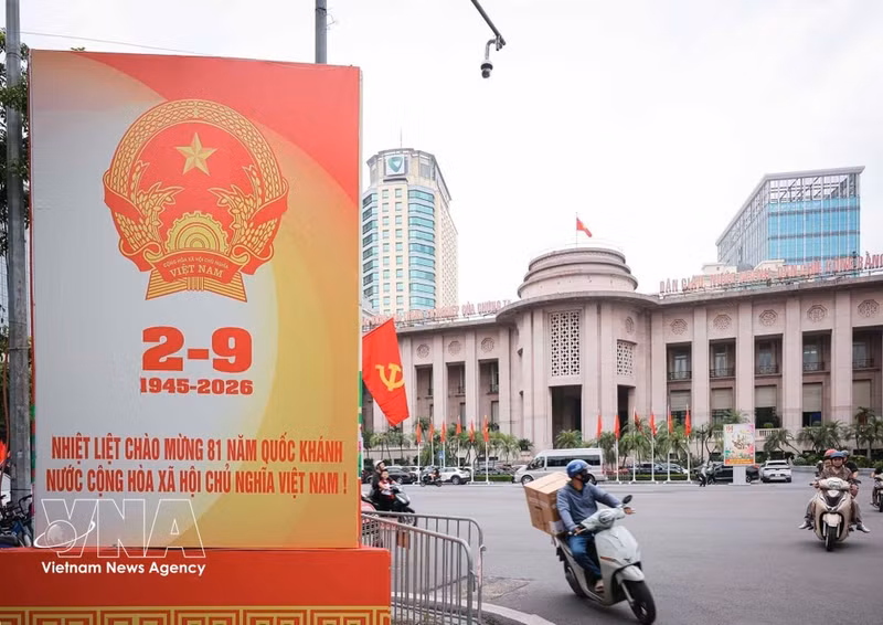 Una gran valla publicitaria con motivo del Día Nacional se instala frente a la sede del Banco Estatal de Vietnam.