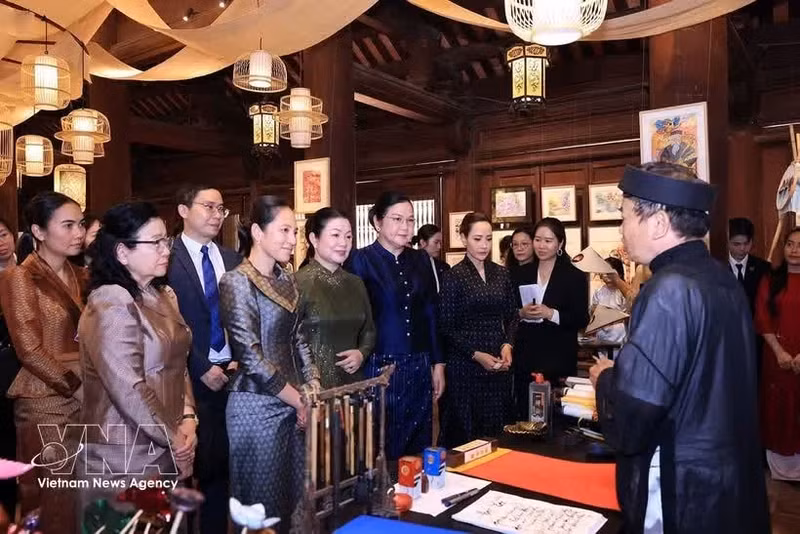 Las damas escuchan una presentación sobre el arte de la caligrafía vietnamita. (Foto: VNA)