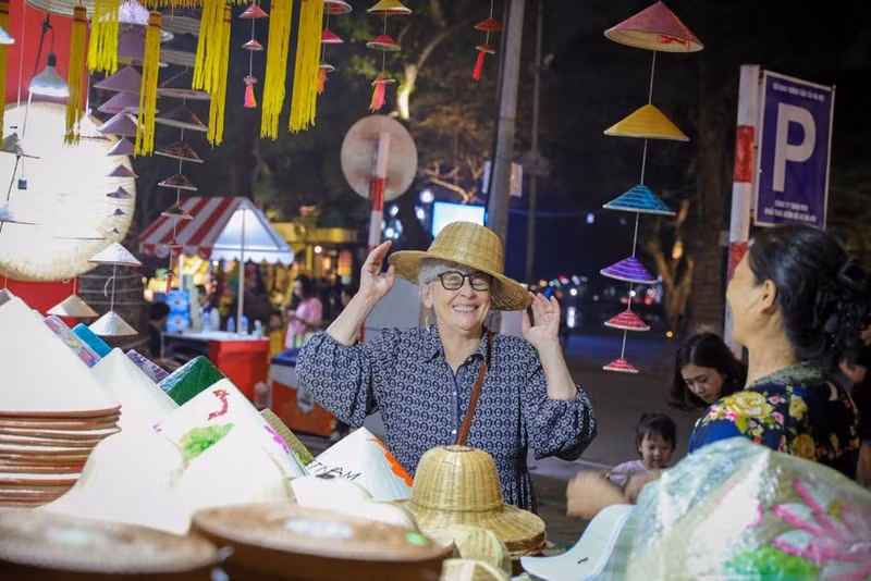 Una extranjera se deleita con productos tradicionales vietnamitas cuando visita Hanói. (Foto: VNA)