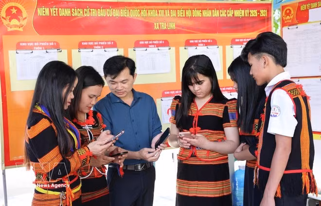 Los habitantes de Xo Dang (comuna de Tra Linh, ciudad de Da Nang) ven vídeos e infografías en sus teléfonos que les guían sobre cómo votar. (Foto: VNA)