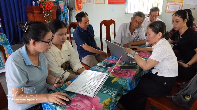Miembros del equipo comunitario de tecnología digital de la aldea Phuong Quy 2, comuna de Ngok Bay, guían a pobladores en la presentación de trámites administrativos en línea. (Foto: VNA)