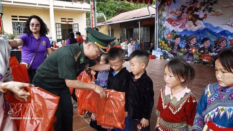 Oficiales de la Guardia Fronteriza de la provincia vietnamita de Lao Cai entregan obsequios a alumnos del centro educativo de Dao Dan San, en la comuna de Si Ma Cai. (Foto: VNA)