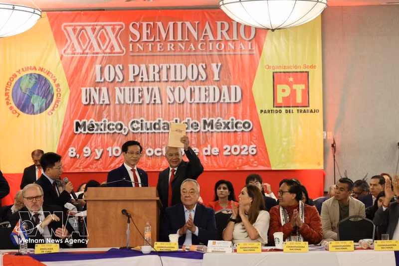 El senador y coordinador nacional del Partido PT, Alberto Anaya Gutiérrez, muestra el libro "Aspiración por un Vietnam fuerte y próspero en la nueva era" en el seminario. (Foto: VNA)