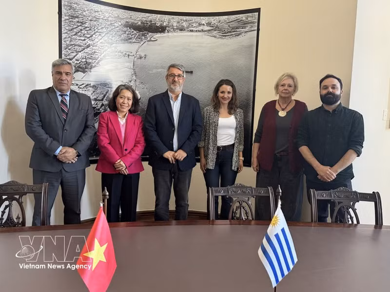 La embajadora Ngo Minh Nguyet (de traje magenta) y el alcalde interino de Montevideo, Justo Onandi (tercero desde la izquierda), junto con representantes de las autoridades locales, posan para una foto tras una sesión de trabajo. (Foto: VNA)