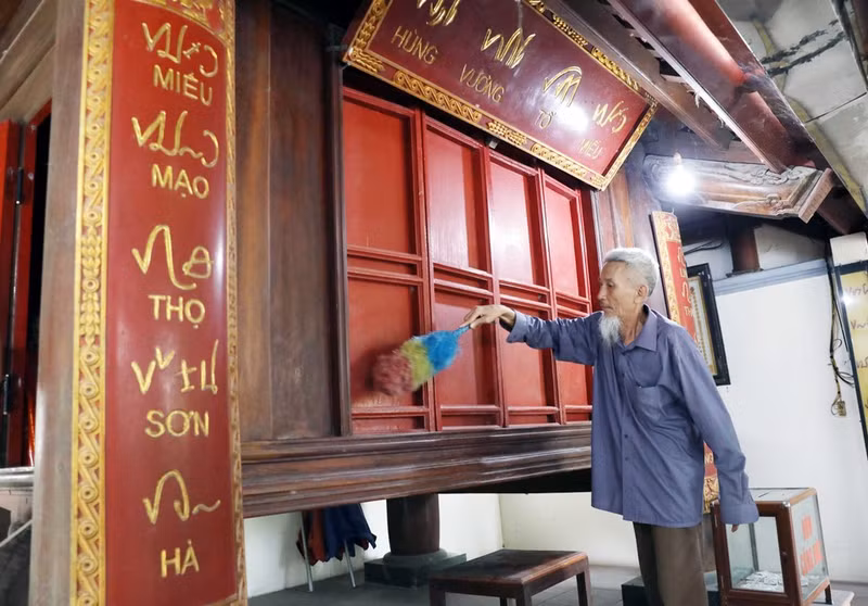Un gran panel caligráfico y un par de tableros con coplas talladas en la antigua escritura Khoa Dau se exhiben en el sanctasanctórum.