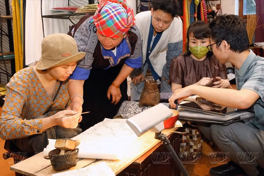Ly Thi Ninh da instrucciones para dibujar cera de abeja en el lino tradicional de la etnia Mong en Che Cu Nha, en el espacio Craft Link, número 51 de la calle Van Mieu, en Hanói. (Foto: Revista Ilustrada de Vietnam)
