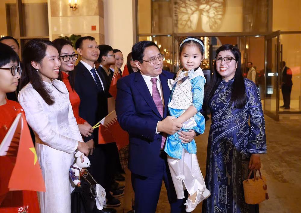 Funcionarios y empleados de la embajada y representantes de la comunidad vietnamita en Catar dan la bienvenida al primer ministro Pham Minh Chinh y a su esposa. (Foto: VNA)
