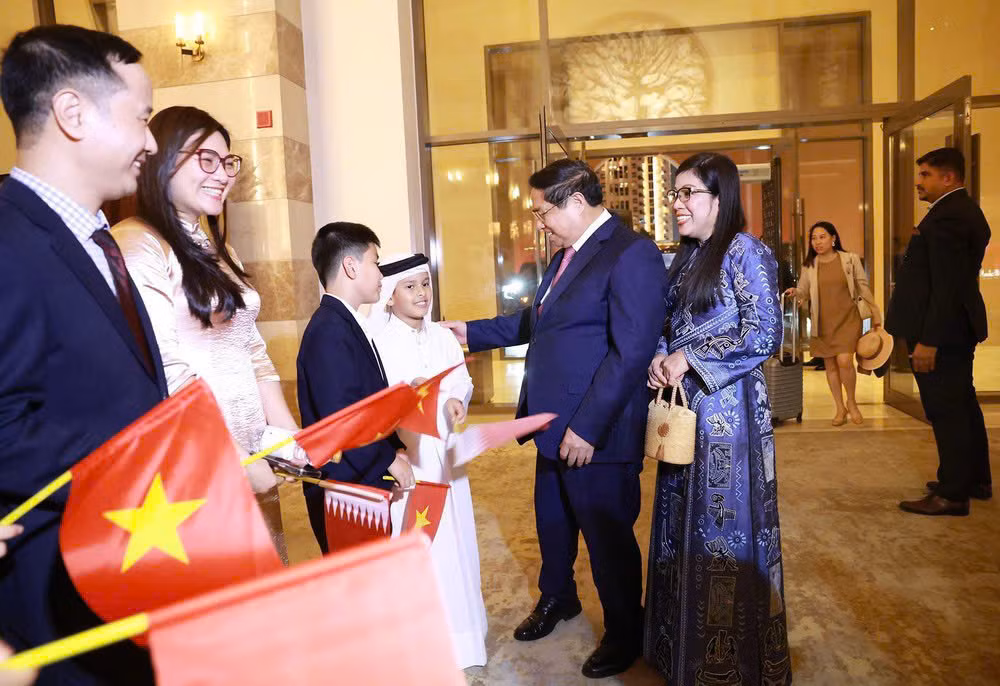 Funcionarios y empleados de la embajada y representantes de la comunidad vietnamita en Catar dan la bienvenida al primer ministro Pham Minh Chinh y a su esposa. (Foto: VNA)