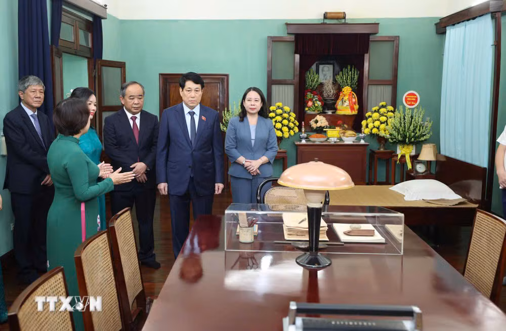 El presidente Luong Cuong escucha una presentación sobre los documentos y artefactos acerca de la vida y el trabajo del presidente Ho Chi Minh en la Casa 67. (Foto: VNA)