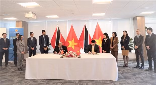 El embajador Dang Hoang Giang, representante permanente de Vietnam ante la ONU, y su homólogo de Trinidad &amp; Tobago, Dennis Francis, en nombre de los gobiernos de cada país, firmaron un Comunicado conjunto para establecer los nexos diplomáticos entre las dos naciones, en Nueva York. (Fotografía: VNA)