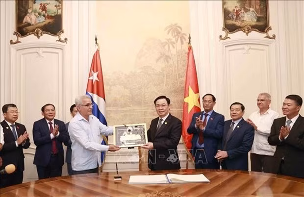 El presidente de la Asamblea Nacional de Vietnam, Vuong Dinh Hue, obsequia al Centro un cuadro de símbolo de la sede del Parlamento vietnamita. (Foto: VNA)