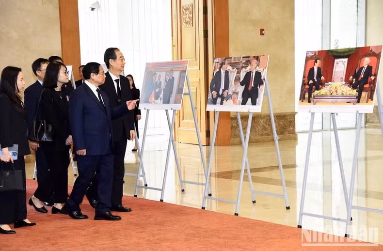 El primer ministro Pham Minh Chinh presenta a su similar surcoreano, Han Duck Soo, algunas fotografías de las actividades exteriores del difunto líder partidista.