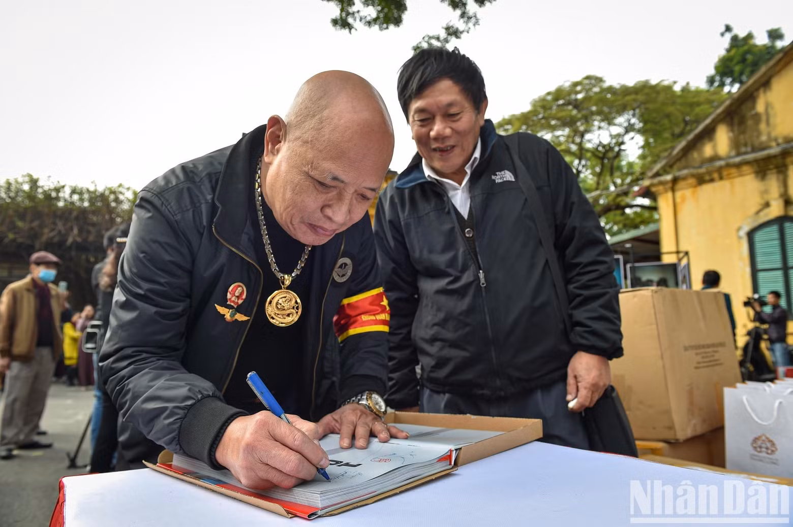 El expiloto del Ejército Popular de Vietnam, Nguyen Hong My, regala a los visitantes libros con su firma.