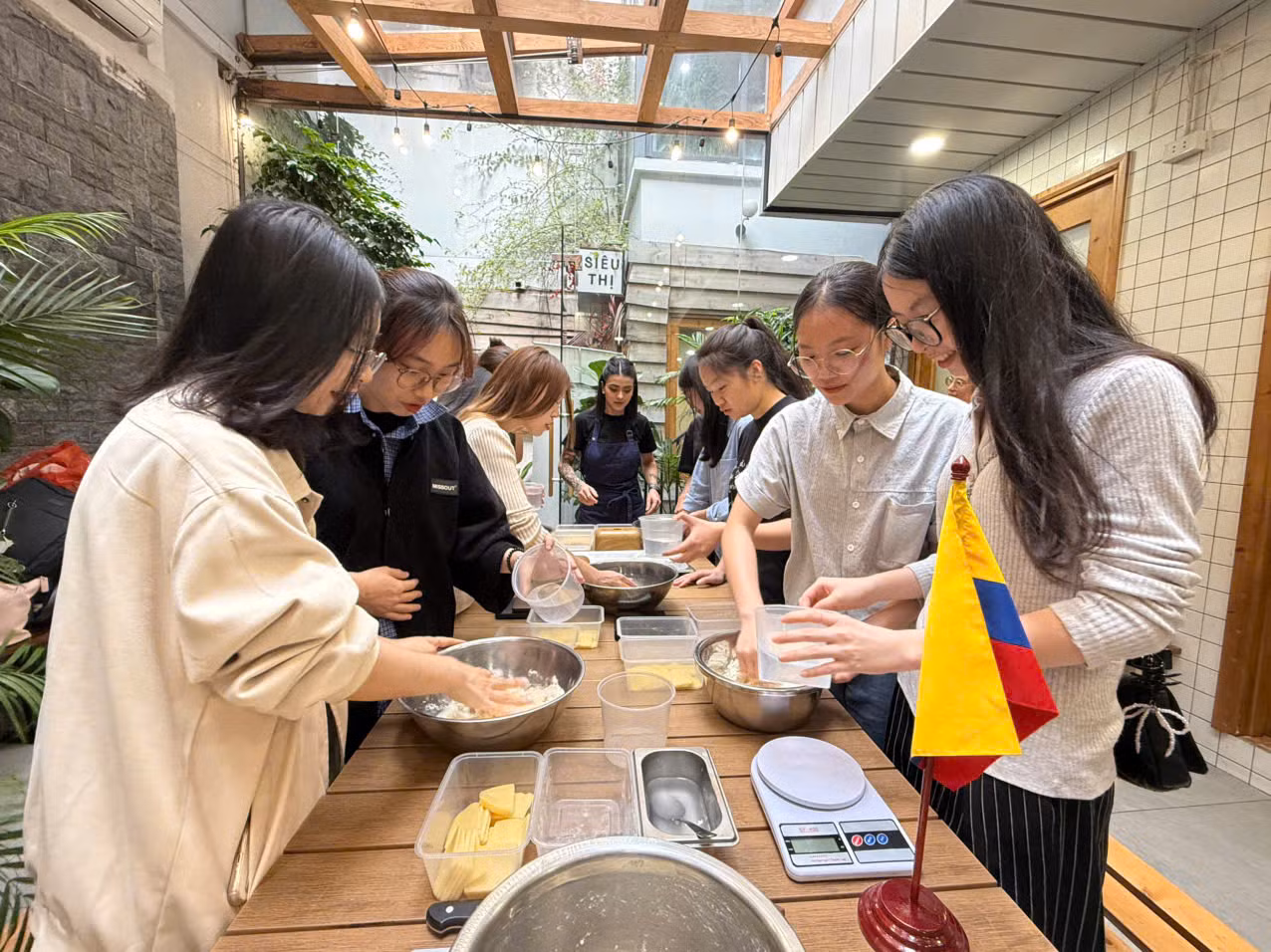 Los estudiantes del Departamento de Español de la Universidad de Hanói hacen la masa y dan forma a las arepas.