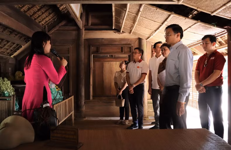 El grupo del trabajo del periódico Pasaxon visita la casa Nguyen Sinh Sac, padre del Presidente Ho Chi Minh, en la aldea Sen.