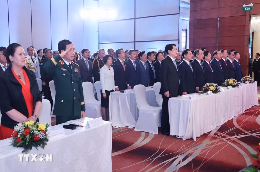 Los asistentes saludan a la bandera nacional.