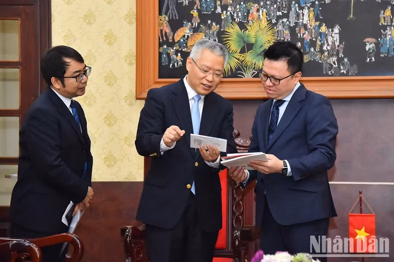 Quoc Minh y Hu Zhaoming intercambian opiniones al margen de la reunión.
