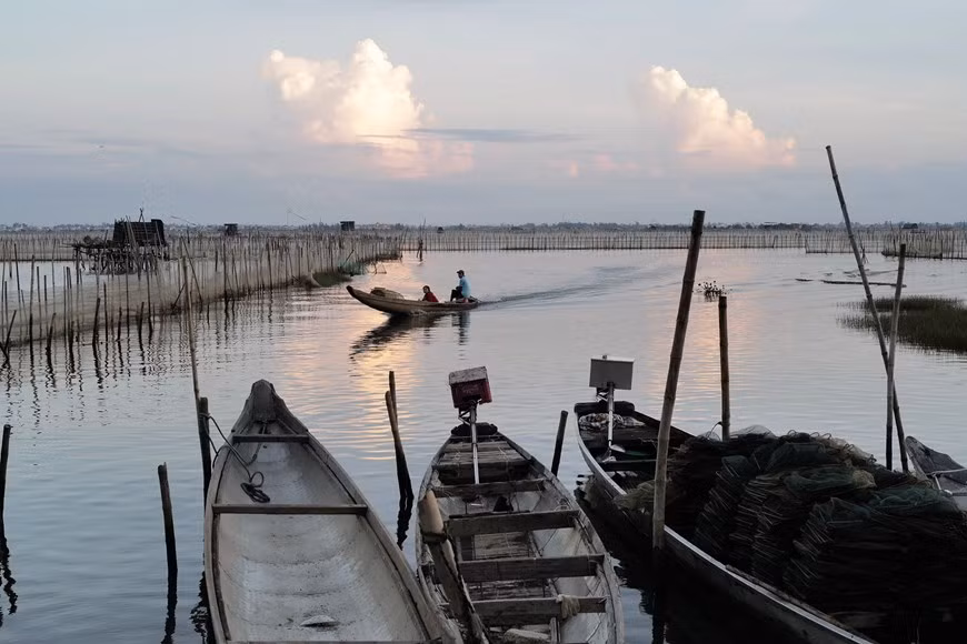 Un barco regresa a la orilla después de una noche de pesca en la laguna. Un barco regresa a la orilla después de una noche de pesca en la laguna.
