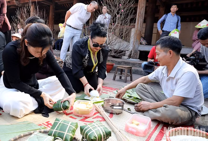 Los visitantes hacen banh chung (pastel cuadrado de arroz glutinoso).