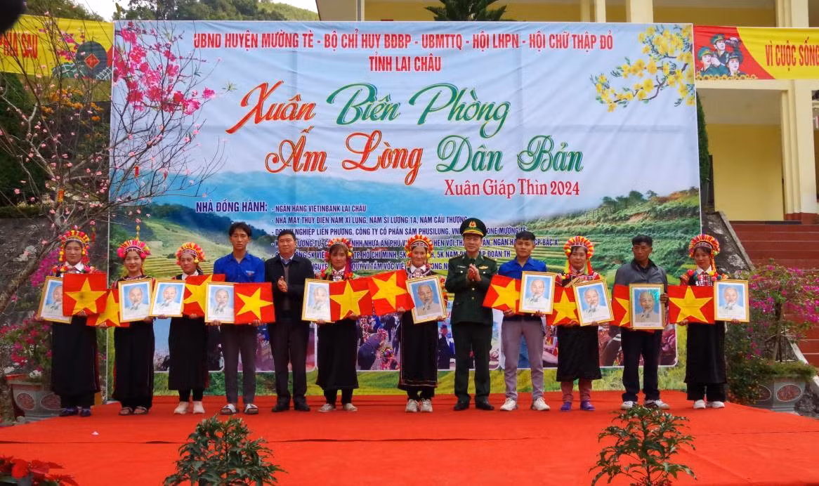 Representantes del Alto Mando de la Guardia Fronteriza de la provincia norteña de Lai Chau otorgan la bandera nacional y el retrato del Presidente Ho Chi Minh a los pobladores de la aldea de Tho Ma, comuna de Pa Ve Su, distrito de Muong Te. Representantes del Alto Mando de la Guardia Fronteriza de la provincia norteña de Lai Chau otorgan la bandera nacional y el retrato del Presidente Ho Chi Minh a los pobladores de la aldea de Tho Ma, comuna de Pa Ve Su, distrito de Muong Te.