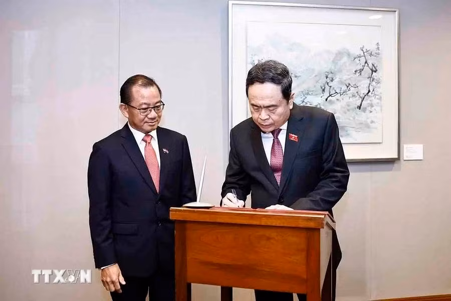 Thanh Man escribe en el libro de visitas del Parlamento de Singapur.