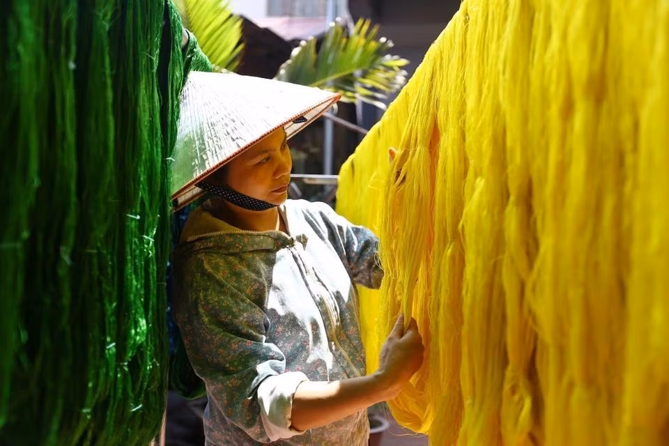 Secando el hilo de seda después de ser teñido en el taller del artesano Nguyen Anh Son en el pueblo de seda Van Phuc.