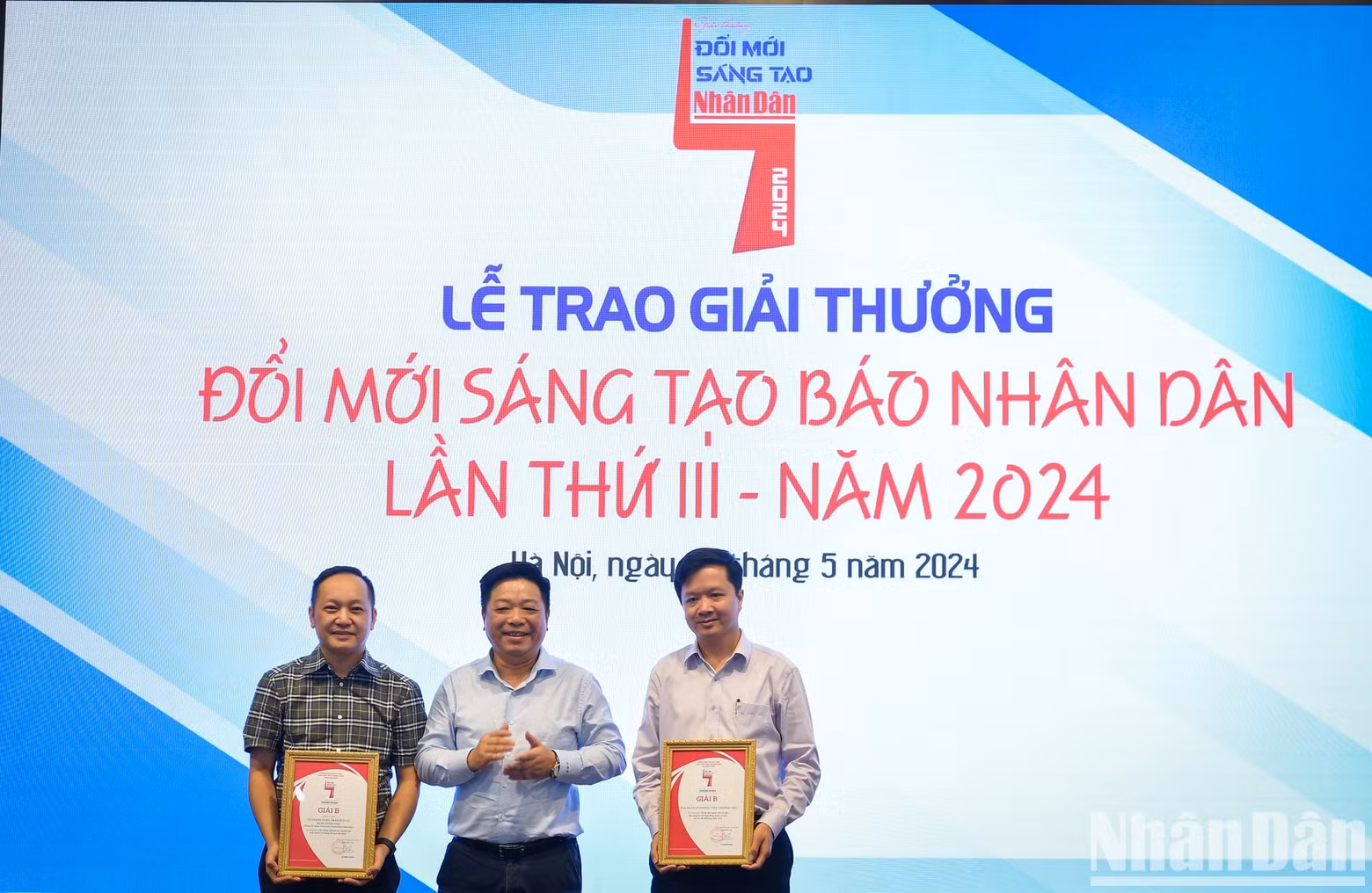 Que Dinh Nguyen, vicesecretario del Comité del Partido y redactor subjefe del periódico Nhan Dan, entrega los premios B a los grupos de autores.