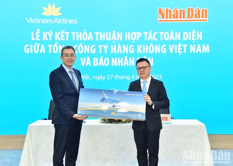 Ngoc Hoa entrega un obsequio al jefe de Nhan Dan, Le Quoc Minh.