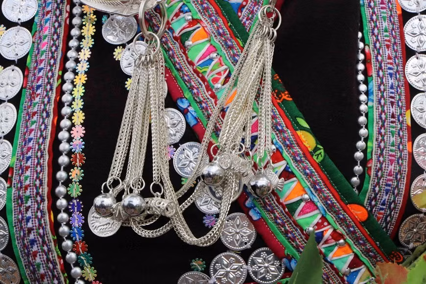 Los accesorios hechos de plata, como pulseras y brazaletes, y patrones decorativos están intrincadamente tallados en los trajes de las mujeres Lao. Los accesorios hechos de plata, como pulseras y brazaletes, y patrones decorativos están intrincadamente tallados en los trajes de las mujeres Lao.