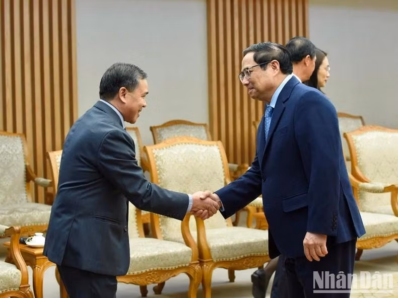 El primer ministro Pham Minh Chinh saluda a los miembros de la delegación laosiana.
