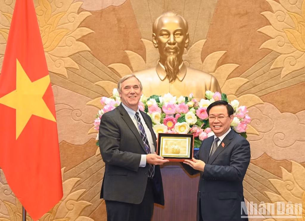 Dinh Hue entrega un regalo de recuerdo al visitante estadounidense.