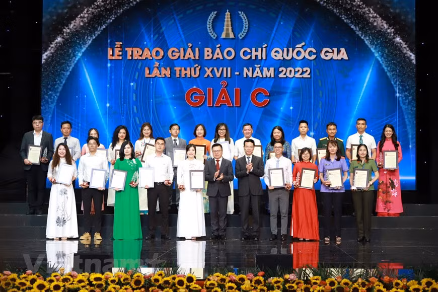 Le Quoc Minh, presidente-editor del diario Nhan Dan, subjefe de la Comisión de Comunicación y Educación del Comité Central del PCV y titular de la Asociación de Periodistas del país y el ministro de Información y Comunicación, Nguyen Manh Hung, otorgan el Premio C a los autores y grupos de autores.