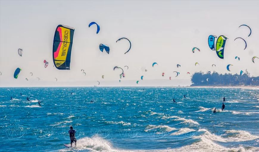 En la temporada de viento del norte, los deportes de surf atraen a muchos turistas, especialmente el parasailing y el windsurf. (Foto: Huu Thanh) En la temporada de viento del norte, los deportes de surf atraen a muchos turistas, especialmente el parasailing y el windsurf. (Foto: Huu Thanh)