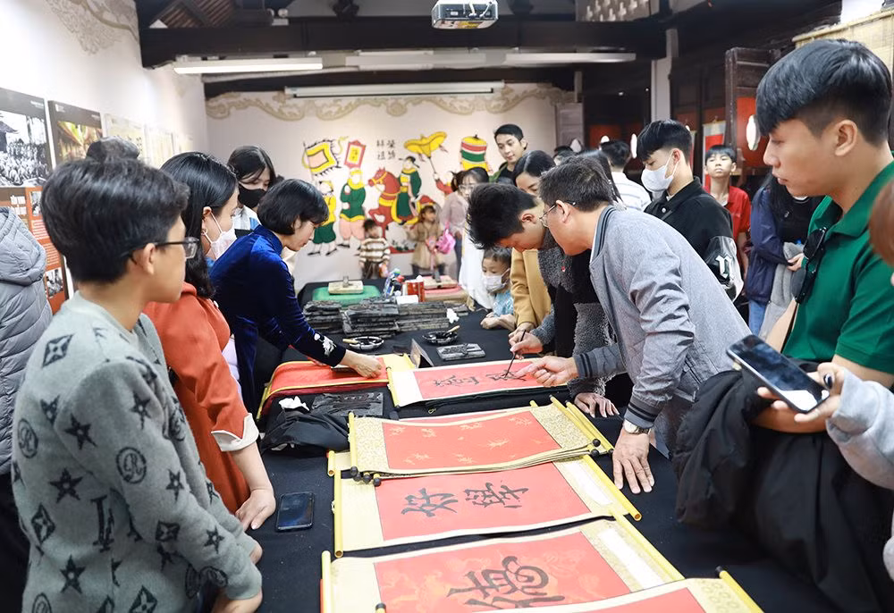 Los turistas aprenden a escribir su propia caligrafía para la buena suerte al comienzo del Año Nuevo.