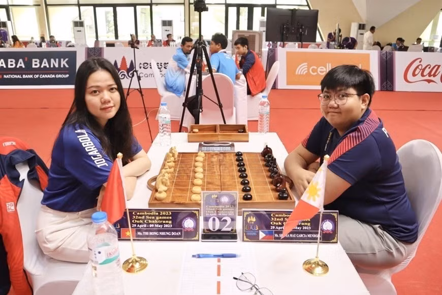 La jugadora vietnamita Doan Thi Hong Nhung (izquierda) obtuvo una medalla dorada al vencer a Shania Mae García Mendoza (Filipinas) en el partido de vuelta de la ronda final de Ouk Chaktrang, un tipo de ajedrez khmer en los SEA Games 32.