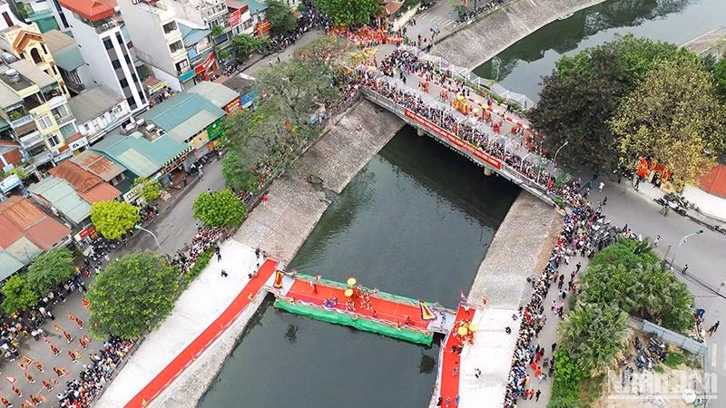 La ceremonia de procesión del palanquín del santo a través del río To Lich.