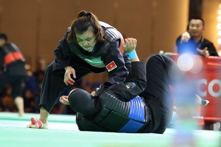 Quang Thi Thu Nghia, (cinturón rojo, derecha) derrotó a Nia Larasati de Indonesia (cinturón azul) en la ronda final de Pencak Silat, en la categoría de lucha de 65-70 kg, para llevar una presea dorada a la selección vietnamita.
