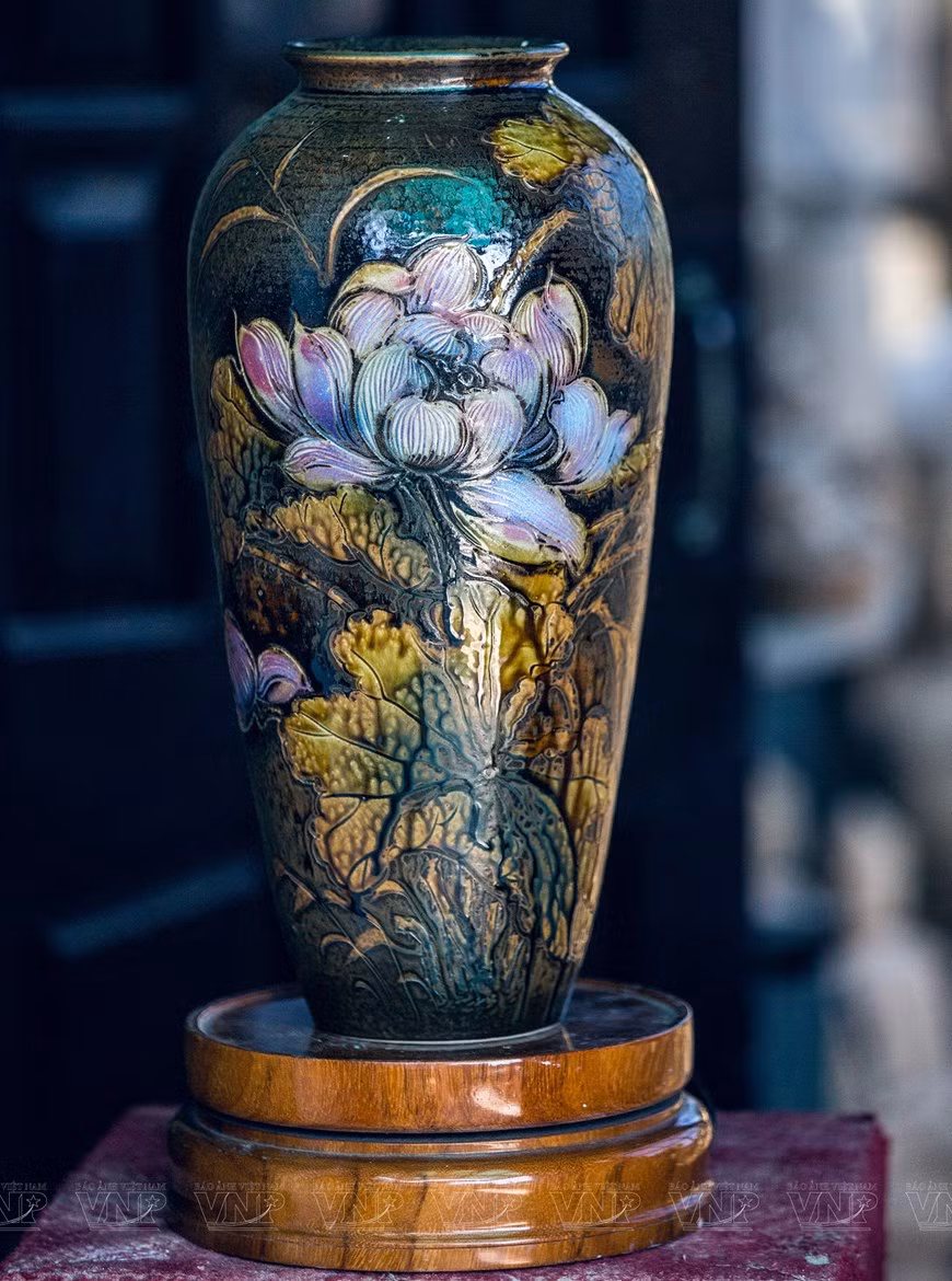 Hojas y flores de loto en jarrón de cerámica.