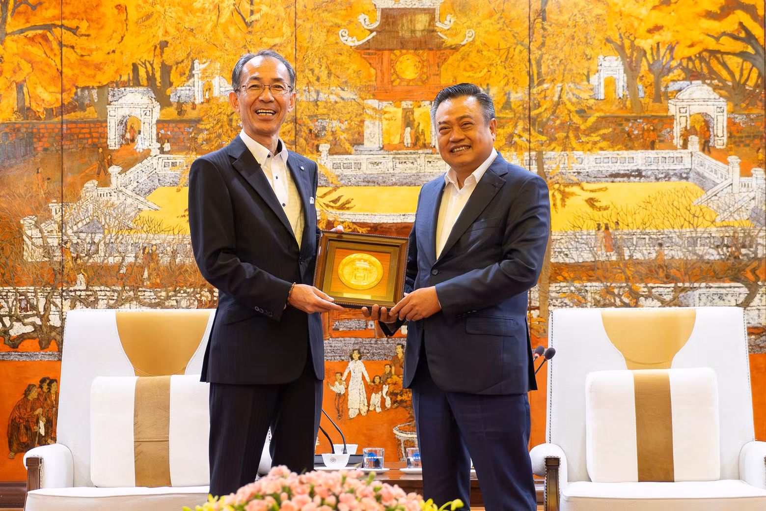 El presidente del Comité Popular de Hanói, Tran Sy Thanh (derecha), entrega un souvenir al vicealcalde de la ciudad de Fukuoka, Eiichi Nakamura. (Fotografía: hanoimoi.com.vn)