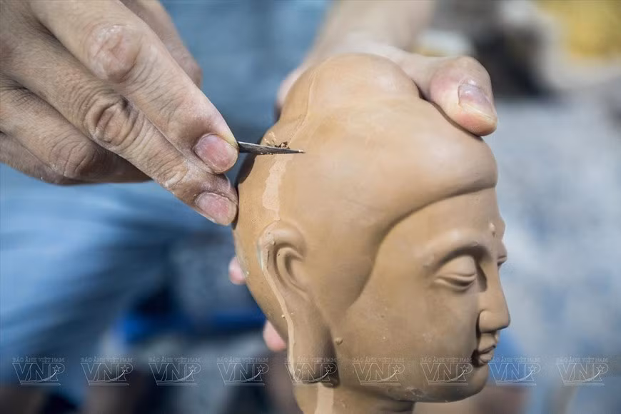 Artesano trabaja la imagen de Buda para darle una forma más adecuada.