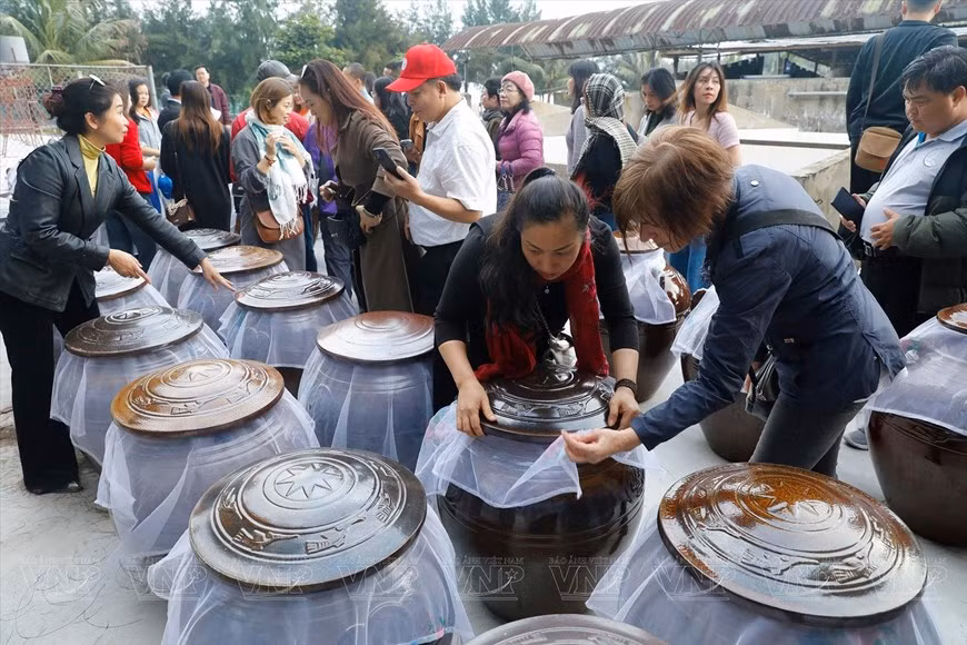 Turistas visitan una fábrica de salsa de almejas en Con Den.